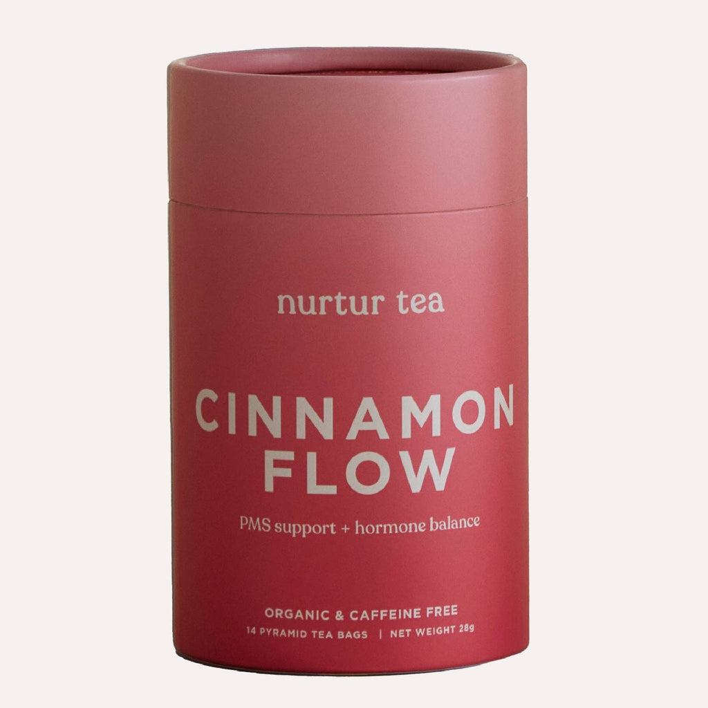 Red cylindrical container of 'Cinnamon Flow' tea by Nurtur Tea on a white background